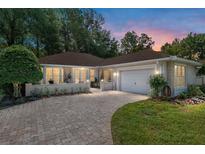 Charming single-story home featuring a brick driveway, manicured lawn, and attached two-car garage at 7242 Sw 115Th Pl, Ocala, FL 34476