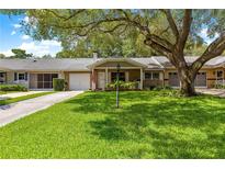 Inviting one-story home with a well-manicured lawn and mature oak tree at 8850 Sw 97Th St # C, Ocala, FL 34481