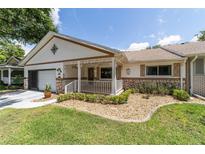 Charming single-story home with a cozy front porch and well-manicured landscaping at 8881 Sw 94Th St # E, Ocala, FL 34481