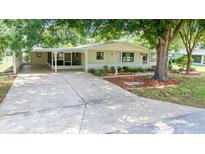 Well-maintained single story home featuring a driveway, carport, landscaping, and lawn at 8973 Sw 104Th Pl, Ocala, FL 34481
