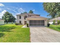 Charming two-story home with a well-manicured lawn, screened garage, and inviting curb appeal at 4602 Se 28Th St, Ocala, FL 34480