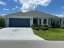 Charming single story home with a well-maintained front yard and blue garage door at 530 Casteel Ave, The Villages, FL 32163