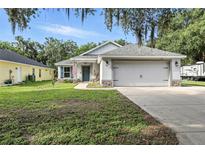 Charming single-story home with a two-car garage, green lawn, and inviting curb appeal at 710 Barwick St, Wildwood, FL 34785