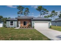 Charming single-story home with a manicured lawn, two-car garage, and inviting front entrance at 7364 Sw 133 Ne Loop, Ocala, FL 34473