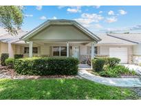 Charming single-story home with a covered front porch, stone accents, and well-maintained landscaping at 9065 Sw 82Nd Ter # G, Ocala, FL 34481