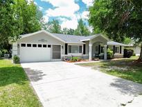Charming single-story home with a well-manicured lawn, driveway, and two-car garage at 10130 Sw 61St Terrace Rd, Ocala, FL 34476