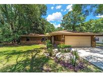 Charming single-story home boasts a well-manicured lawn, mature trees, and a two-car garage at 10615 Sw 68Th Ter, Ocala, FL 34476