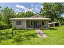 Charming home with a metal roof, inviting front porch, and well-maintained lawn and garden at 1330 Ne 55Th St, Ocala, FL 34479
