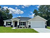 Beautiful single-story home with manicured lawn and attractive landscaping under a blue sky at 13305 Sw 114Th Pl, Dunnellon, FL 34432