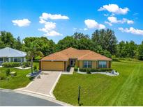 Charming one-story home with manicured lawn, mature trees, and well maintained landscape at 13835 Se 85Th Cir, Summerfield, FL 34491