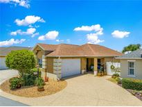 Charming home featuring an attached two car garage and a well maintained front yard with decorative landscaping at 1751 Brandenburg Ct, The Villages, FL 32163