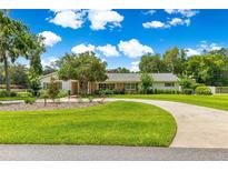 Beautifully landscaped yard with a winding driveway leading to a charming single-story home at 1922 Se 13Th St, Ocala, FL 34471