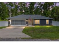 Charming single-story home with a well-maintained lawn and a two-car garage at 6 Sequoia Loop, Ocklawaha, FL 32179