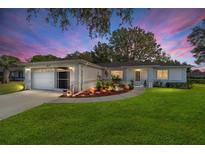 Beautiful one-story home featuring a well-manicured lawn and charming curb appeal during sunset at 6113 Sw 101St Pl, Ocala, FL 34476