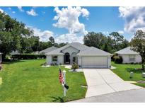 Charming single-story home with a well-manicured lawn and a two-car garage on a sunny day at 6330 Sw 117Th Loop, Ocala, FL 34476
