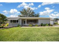 Charming single-story home with a well-manicured lawn, complemented by lush landscaping and a welcoming front porch at 8461 Sw 109Th St, Ocala, FL 34481