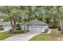 Charming one-story home with a well-manicured lawn and mature trees creating a serene curb appeal at 8775 Sw 192 Ct, Dunnellon, FL 34432
