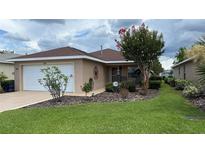 Charming single-story home featuring a well-manicured lawn and delightful landscaping at 9047 Sw 102Nd Cir, Ocala, FL 34481