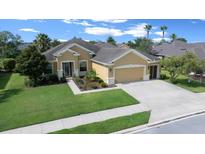 Charming single-story home featuring a well-manicured lawn, lush landscaping, and a spacious driveway leading to an attached garage at 9948 Sw 69Th Ln, Ocala, FL 34481