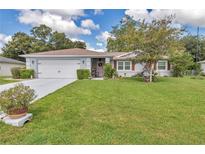 Charming single-story home featuring a well-manicured lawn and inviting curb appeal at 10086 Sw 62Nd Terrace Rd, Ocala, FL 34476