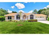 Charming single-story home with a manicured lawn, lush landscaping, and a welcoming entrance at 10819 Sw 84Th Ter, Ocala, FL 34481