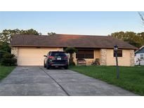 Charming single-story home featuring a well-maintained lawn and driveway with a two-car garage at 10885 Se 74Th Ct, Belleview, FL 34420