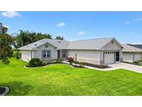 Well-maintained single Gathering home with a lush green lawn and manicured landscaping at 12178 Se 174Th Pl, Summerfield, FL 34491