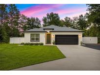 Charming single-story home with a manicured lawn, a two-car garage, and elegant landscaping at 155 Marion Oaks Pass, Ocala, FL 34473