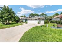 Charming single-story home with a well-manicured lawn and a three-car garage at 16023 Sw 14Th Avenue Rd, Ocala, FL 34473