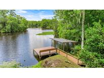 Picturesque dock with bench seating and covered area, overlooking the tranquil lake at 19620 Fox Trl, Dunnellon, FL 34432