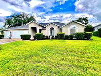 Charming single-story home featuring a well-manicured lawn and welcoming curb appeal at 2100 Nw 50Th Cir, Ocala, FL 34482
