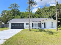 Charming single-story home featuring a well-maintained lawn and a spacious two-car garage at 21111 Sw Honeysuckle St, Dunnellon, FL 34431