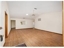 Spacious living room with wood-look floors, neutral walls and ceiling fan at 8959 Sw 96Th Ln # A, Ocala, FL 34481