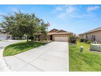 Charming home featuring a well-manicured lawn, mature trees, and an inviting driveway leading to the front entrance at 9222 Sw 97Th Cir, Ocala, FL 34481