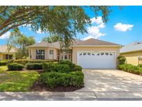 Charming single-story home featuring a two-car garage, well-maintained landscaping, and a light beige stucco exterior at 9746 Sw 89Th Loop, Ocala, FL 34481