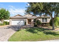 Charming single-story home with a well-manicured lawn and a brick driveway leading to a two-car garage at 9926 Sw 95Th Loop, Ocala, FL 34481