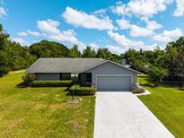 Charming single-story home featuring a well-manicured lawn, attached garage and inviting front yard at 205 Ne 53Rd St, Ocala, FL 34479