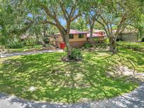 Charming home with a red roof, front yard, and mature trees offering shade at 2676 Se 52Nd Ave, Ocala, FL 34480