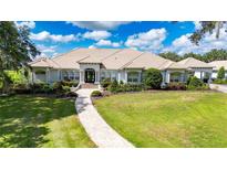 Stunning single-story home featuring a tile roof, lush landscaping and a brick walkway leading to the front entrance at 3440 Sw 66Th St, Ocala, FL 34476