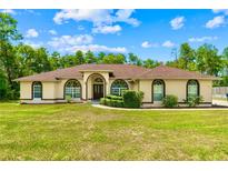 Charming one-story home with a well-manicured lawn and inviting curb appeal with arched windows at 4973 Sw 107Th Loop, Ocala, FL 34476