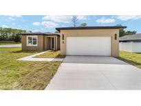 Charming single-story home with a large white garage door and nicely paved driveway at 5 Dogwood Loop Ave, Ocala, FL 34472