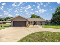 Charming single-story home with a brick facade, well-manicured lawn, and a spacious driveway at 7443 Sw 102Nd Pl, Ocala, FL 34476