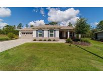 Charming one-story home with a well-manicured lawn, inviting curb appeal, and an attached two-car garage at 9746 Sw 108Th Terrace Rd, Ocala, FL 34481