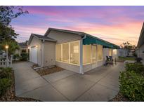 Charming single-story home featuring a cozy screened-in lanai and a well-maintained landscaped yard at 1405 Espinoza Ln, Lady Lake, FL 32159