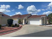 Charming single-story home features a manicured lawn and attached two-car garage at 1815 Puerto Bello Dr, The Villages, FL 32159