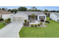 Charming single-story home features a well-manicured lawn and inviting landscaping at 1819 Captiva Ct, The Villages, FL 32162