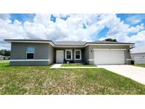 Charming one-story home featuring a well-manicured lawn and an attached two-car garage at 2883 Sw 146Th Place Rd, Ocala, FL 34473