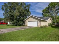 Detached garage with stone accents and a white door is surrounded by a green lawn at 42 Almond Dr, Ocala, FL 34472