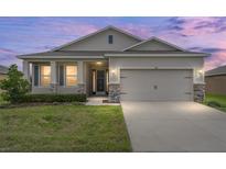 Charming single-story home with a two-car garage, well-maintained lawn, and stone accents at 6175 Sw 88Th Loop, Ocala, FL 34476