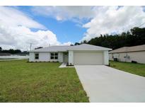 Charming single-story home with a well-manicured lawn and attached two car garage at 9 Hemlock Terrace Ln, Ocala, FL 34472